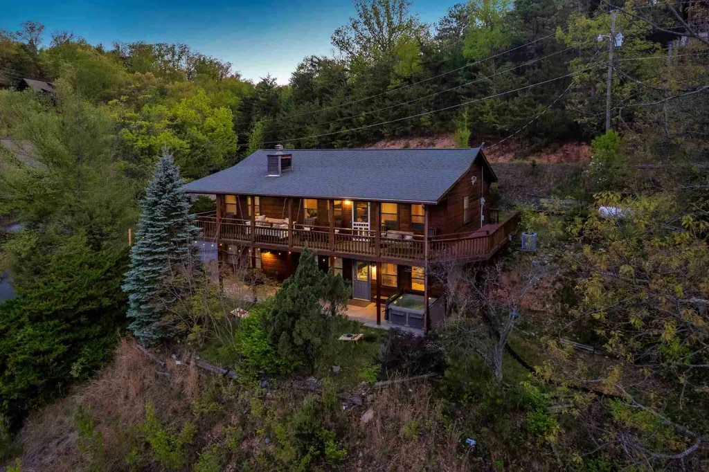Aerial view of the cabin and its back deck among the trees at dusk