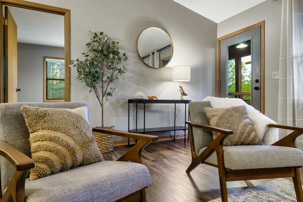 Two armchairs and a round mirror in a quiet sitting area inside the cabin