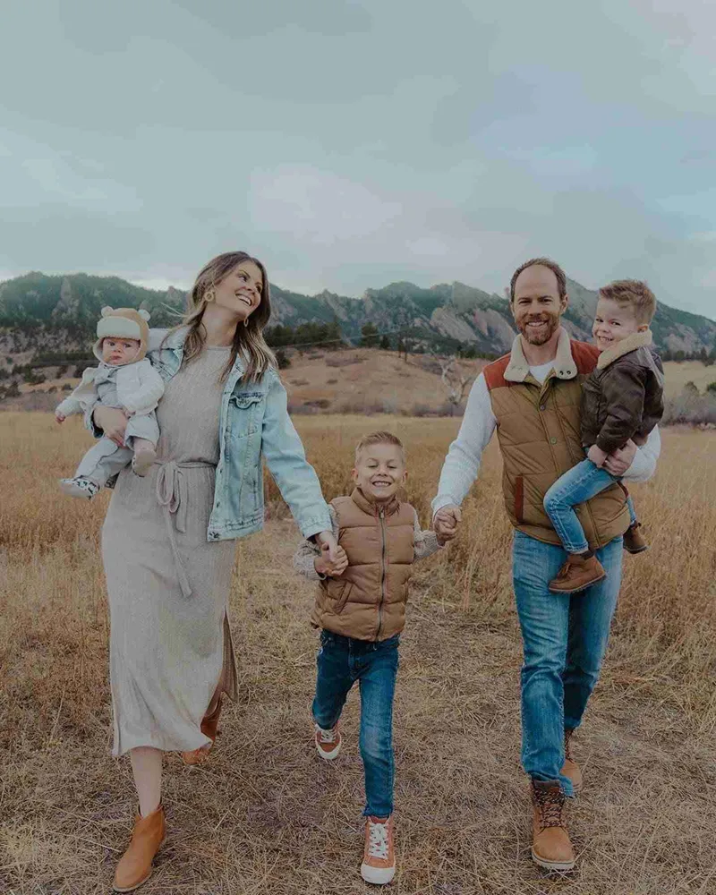 Austin Gardner and his family, the hosts of Smoky Mountains Lodge, walking hand in hand through a meadow